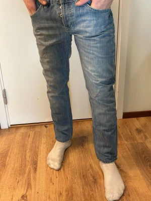 Dondup jeans  - Säljer ett par klassiska blå jeans med rak passform och kontrastsömmar. Jeansen har fem fickor, bälteshällor och en snygg tvättad look. Perfekta för en avslappnad stil och passar till det mesta i garderoben.