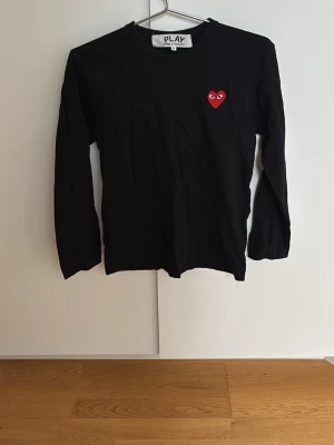 Svart långärmad topp från Comme des Garçons - Svart långärmad topp från Comme des Garçons PLAY st S för endast 299kr! Nypris 1100kr