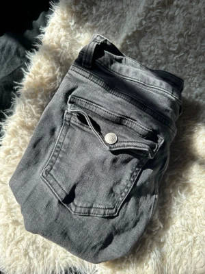 Svarta jeans - Säljer ett par jeans med snygga ficklock och silverfärgade knappar bak. Jeansen är från lager157 och modellen 90s boot. Det är bootcut jeans. 