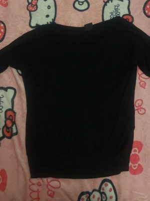 Svart tröja från Gina Tricot - En enkel svart tröja från Gina Tricot i storlek XS. Tröjan har rund halsringning och långa ärmar, perfekt för en clean och stilren look. Materialet känns mjukt och stretchigt, vilket gör den bekväm att bära till det mesta.