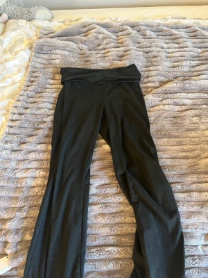 Yoga pants  - Säljer ett par svarta leggings med bootcut-ben och hög midja. De har en bred linning upptill och är tillverkade i ett stretchigt material som sitter skönt på kroppen. Perfekta för en avslappnad och trendig look.