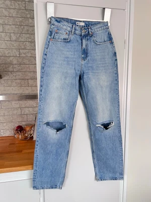 Ljusblå raka slitna jeans från Gina Tricot, stl 36 - Ljusblå slitna jeans från Gina Tricot med raka ben och hög midja. Jeansen har en snygg tvättad look och är tillverkade i bomull. Sparsamt använda. 