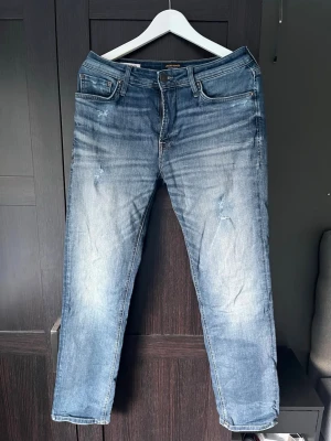 Blå raka jeans från Jack & Jones - Snygga blå jeans från Jack & Jones i modellen regular clark. Jeansen har egengjorda slitningar! Skriv vid funderingar!