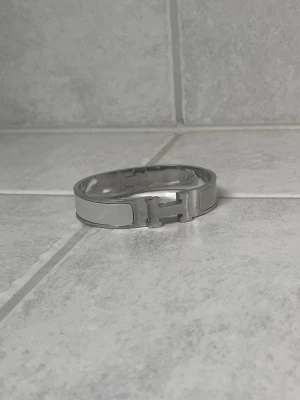 H armband - Snyggt armband i färgerna grå och silver. Armbandet är i mycket bra skick. Inga tillbehör finns kvar tyvärr
