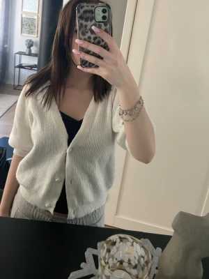 Stickad kofta  - Fin vit kofta med puff armar.