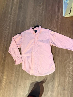 Rosa skjorta från Ralph Lauren - Säljer en till rosa RL skjorta även denna var fel storlek. Fint skick men kanske en aning urtvättad