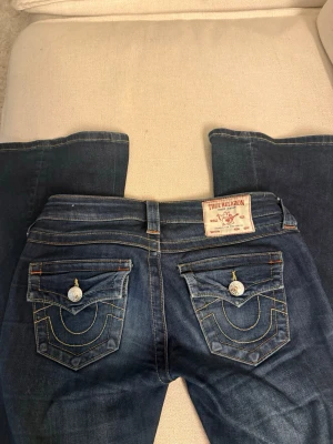 True Religion bootcut jeans blå - Säljer ett par blå bootcut joey jeans från True Religion i storlek 23.