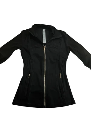 Svart define jacket med dragkedja lululemon - Svart/guld define jacket med figurnära passform och hel dragkedja framtill som är exakt likadan som lululemon . Jackan har två sidofickor med dragkedjor och hög krage. Perfekt för dig som vill ha en stilren och funktionell jacka till vardags.