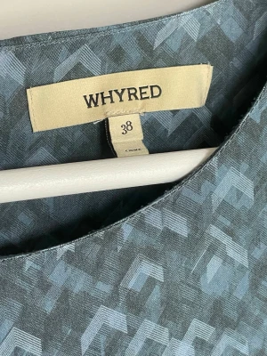 Mönstrad blus från Whyred strl 38 - Snygg blågrå blus från Whyred med diskret geometriskt mönster. Blusen har rund halsringning och långa ärmar. Materialet ser ut att vara mjukt och följsamt, perfekt för en stilren look. Strl 38. Kommer från djur- och rökfritt hem.