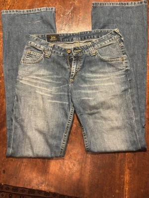 Lågmidjade jeans - Kvalitativa Lee jeans, midrise och utsvängda vid benen. Inga defekter utom en liten blekrand på baksida ben ner vid foten som inte syns. 🩷37 cm rakt över midjan, 82 cm innerbenslängd 