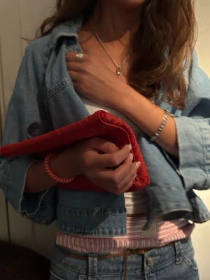Röd kuvertväska i quiltad look - Oanvänd trendig ljusblå jeansjacka med croppad passform och klassisk krage. Jackan har knappstängning framtill. Perfekt att slänga över en t-shirt för en avslappnad look. Ny pris 499