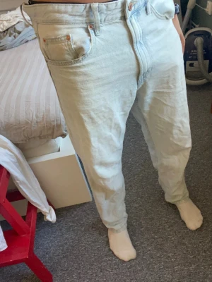 Jeans - Behärska wide 90s - Säljer ett par ljusblå jeans från behärska med klassisk femficksdesign och raka ben. Jeansen har en hög midja och är tillverkade i bomullsdenim. Perfekta för en avslappnad och trendig look. Storlek 30 30