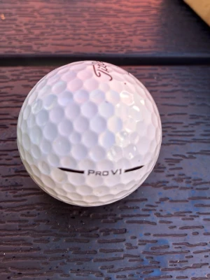 Vit Titleist Pro V1 golfboll - 10 st - Säljer en vit golfboll av modellen Pro V1 från Titleist. Bollen har klassisk dimple-design och är tillverkad i slitstarkt material för bästa prestanda på golfbanan. Perfekt för dig som vill ha en boll med bra känsla och kontroll.
