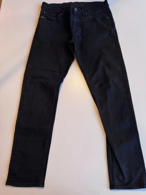 ~Tiger of Sweden~ - Snygga svarta jeans från Lee med rak passform och klassisk femficksdesign. Jeansen har bälteshällor, knappgylf och är tillverkade i ett slitstarkt denimtyg. Perfekta för dig som gillar en enkel och stilren look.