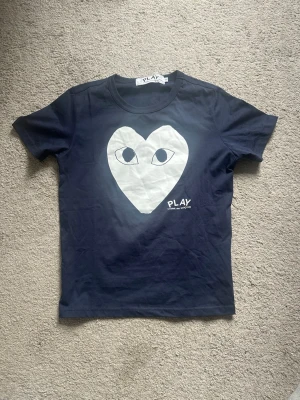 Mörkblå Comme des Garçons t-shirt - Säljer denna Comme des garcon t-shirt eftersom den är för liten för mig, helt oanvänd. Skriv vid frågor eller funderingar