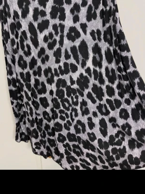 Leopardmönstrad klänning Gina Tricot - Säljer en snygg leopardmönstrad klänning från Gina Tricot i svart och grått. Klänningen har rund halsringning och är i ett mjukt, stretchigt material som ger en bekväm passform. Perfekt för dig som vill sticka ut lite extra.