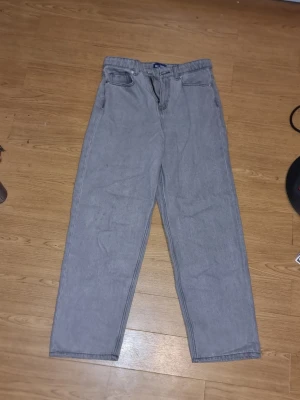 Grå raka jeans med hög midja - INSTABOX!!! Säljer ett par grå jeans med rak passform och hög midja. Jeansen har klassiska fem fickor och stängs med dragkedja och knapp. Perfekta för en avslappnad och trendig look. Materialet är denim i bomull.