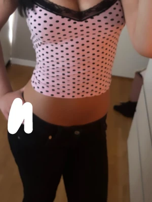 rosa prickigt camisole-linne med spets från H&M Divided - Superfint och helt oanvänt linne från H&M Divided! Ljusrosa med svarta prickar och söt svart spetskant i urringningen. Sitter jättefint och har smala axelband. Perfekt för Y2K-, coquette- eller Pinterest-looken.