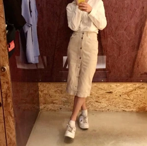 Beige jeanskjol från Weekday - Beige jeanskjol med silvriga knappar. 100% bomull. Från Weekday. Kan mötas upp eller frakta mot fraktavgift