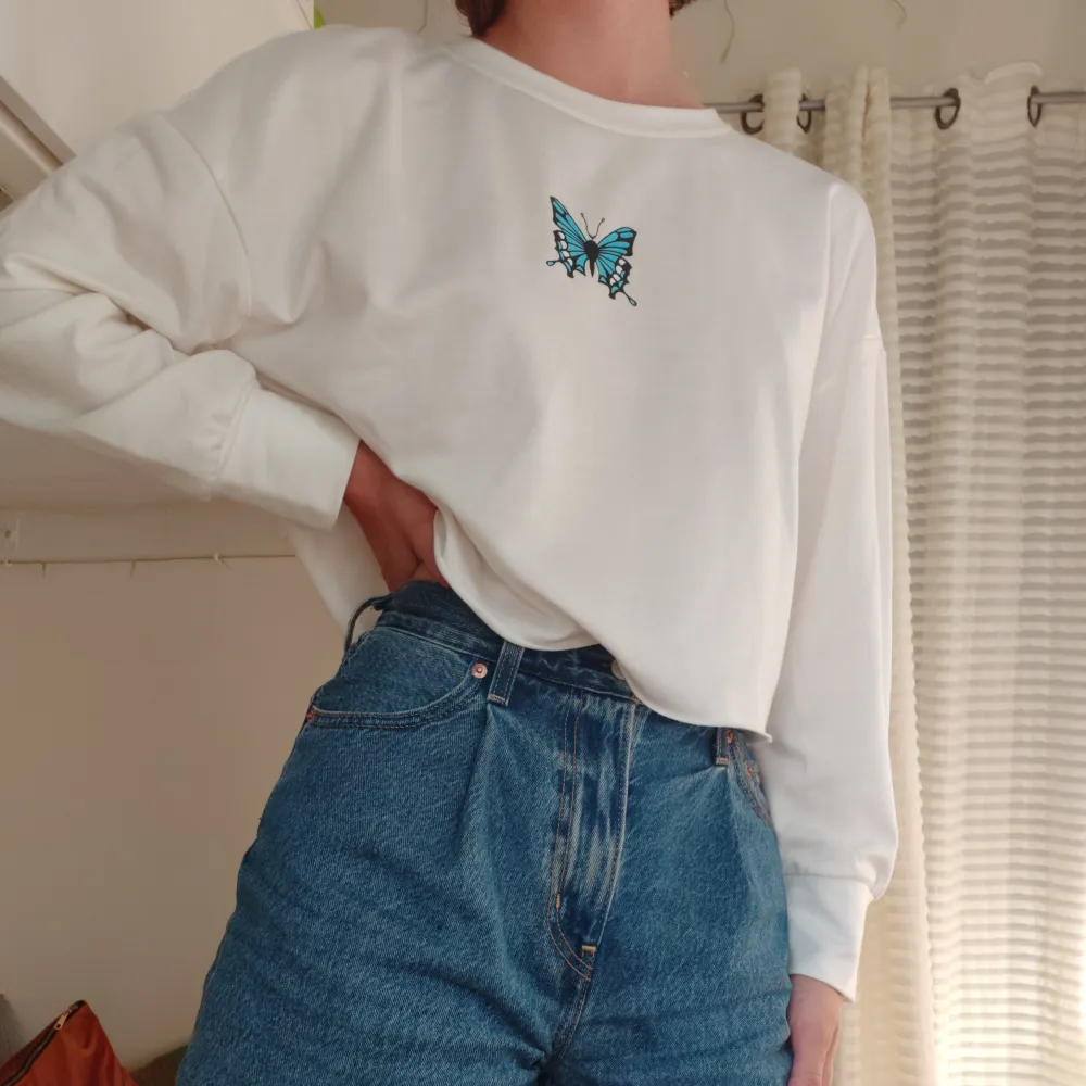 Snygg och skön croppad sweatshirt med tryck av en blå fjäril på framsidan 🦋 aldrig använd och i storlek s. Toppar.