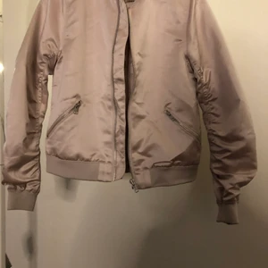 Jacka  - En rosa bomberjacka som har en dragkedja på ryggen, jackan är ifrån Wera i stl 34.