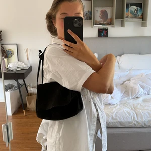 Mockaväska  - Svart mockaväska. Går att använda som axelväska och Cross-body. 