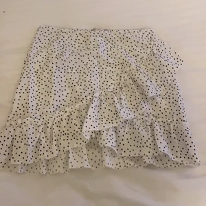 Volangkjol  - En jättefin vit prickig volangkjol                                            (Oanvänd) köpt från SHEIN                                                                           Säljer eftersom den var lite för liten på mig 