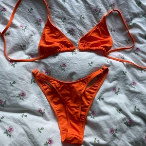 Orange bikini helt oanvänd - ALDRIG ANVÄND! Färgen är mest lik tredje bilden. Orange bikini i storlek M men var för liten för mig! Lite liten i storlek, toppen går dock att knyta så anpassningsbar. Båda delarna köpes tillsammans för 150kr +frakt! 