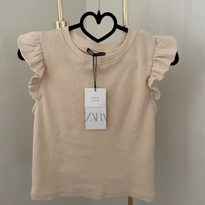 Zara volangtopp - Säljer en helt ny volangtopp från Zara. Den är lite ljusbeige i färgen, och superfin till sommaren 🌸 säljes för 79 kr + frakt 🦋
