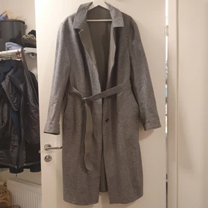 Vintage kappa - Vintage kappa i perfekt skick. Kappan är vändbar så man kan ha den mönstrade sidan utåt eller den ljusgrå. Går ner till mitten av min vad och jag är 170cm. Skulle gissa att det är en gammal herrjacka och storleken är ungefär XL. Den sitter snyggt oversize på mig och jag är vanligtvis XL i damstorlek.