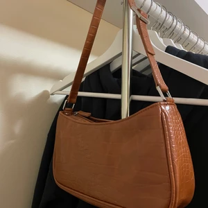 Baguetteväska  - Säljer en brun baguetteväska från monki. Bandet är justerbart. Finns inte längre på hemsidan och nypris är 200kr men säljer för 90kr, pris kan eventuellt diskuteras. Den är sparsamt använd, kontakta vid frågor elr intresse av att köpa😊