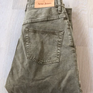 Acne 27/32 26/32 - Ett par acne byxor i grön/beige färg och mjukt tyg (ej jeanstyg). Storleken är 27/32 men är för tighta för mig som är 27 och passar nog en 26 eller 25 bättre. Snygga och höga i midjan. Har köpt dem på utförsäljning en gång och säljer nu billigt till någon de passar bättre. Fint skick och endast använda lite då de alltid varit för tighta för mig. 