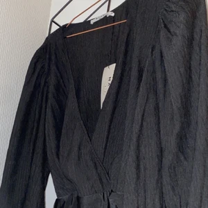 Svart body - En svart body från NAKD🖤Strl 36! Djup urringning och luftiga, stora armar. Passar perfekt till fest och nyår🖤ALDRIG använd bara testad en gång (prislapp hänger kvar). Väldigt skönt material och väldigt luftig tröja. Fler bilder kan skickas på dm🖤