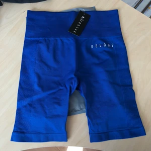 Relode träningsshorts - Jättefina blåa träningsshorts från relode som aldrig kommit till användning. Lapp & påse finns kvar. Shortsen slutar ovanför knäna.