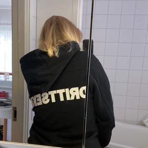 Svart hoodie med text på ryggen: ”DRITTSEKK” Storlek L 
