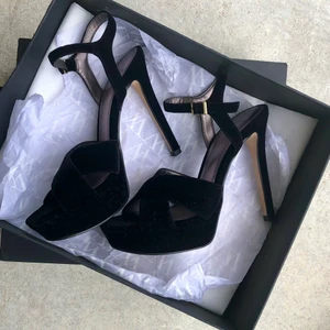 Svarta velvet högklackade skor, fr Mango -  Snygga svarta velvet högklackade skor, från Mango.   Märke: Mango.  Storlek: 36 Högklackade skor, klacken ca 12-13 cm. Platån ca 3-3,5cm.   Pris: 80 kr + frakt 66 ( spårbart)  Skick : Dem är sparsamt använda, har inget att anmärka på”. Så fina.  Se bilder.   Meddelande om fler bilder önskas.  🌸 Har flera annonser uppe på kläder/saker så samfraktar.  🌸Övrigt kläderna kommer från  rökfritt och djurfritt hem.