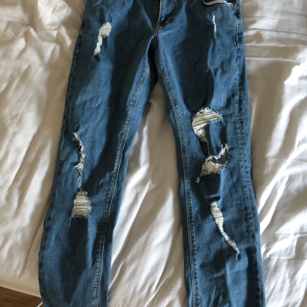Jeans i mellanblå tvätt med revor. Använda endast en handfull gånger. . Jeans & Byxor.