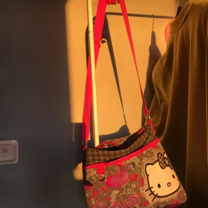 Hello Kitty väska - söt rätt rymlig väska, använder inte så mycket så. Den har justerbart axelband. Ena knappen är dock borta på framlfickan.
