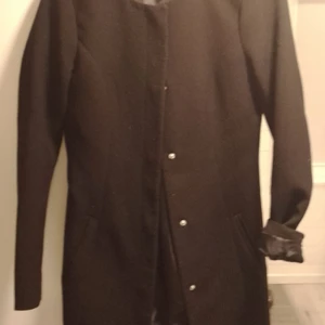 Jacka  - I tunnt material lång modell i storlek XS