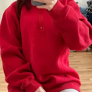 Röd tjocktröja/hoodie, med dragkedja en bit. Finns ingen lapp om storlek kvar men skulle säga att det är en XL :)