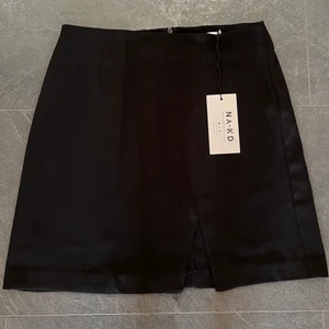 Helt oanvänd kjol från NAKD - Helt ny och oanvänd kjol från NAKD i strl 34. Säljer då den är för stor för mig tyvärr. Kjolen har en liten slits framtill och dragkedja baktill. (Nypris: 299kr) 💕✨ Köparen står för frakt!!!