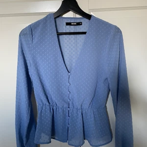 Blus - Ljusblå blus som sitter åt i midjan! 