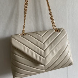 Oanvänd stor handväska - Säljer min helt oanvända handväska som är beige och lite större som jag tycker är supersnyggt🤩 använder bara silver men denna har ”guld” kedjor så jag använder den tyvärr inte😅 säljes för 150kr + frakt!❤️