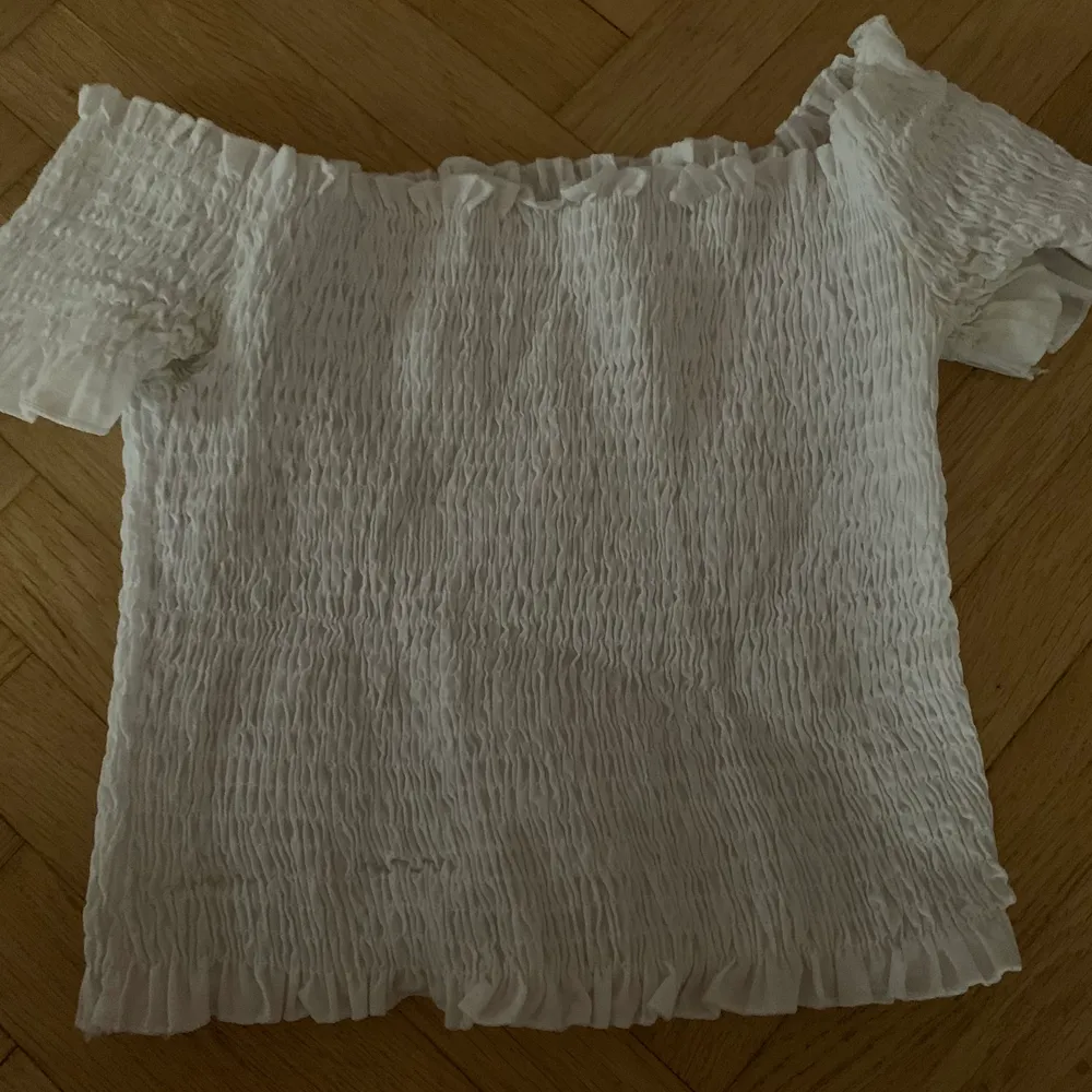 White off shoulder cropped shirt, a bit see through, not too soft. Size S runs for M as well. Skjortor.