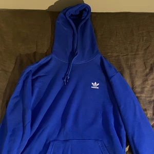 Blå adidas hoodie - En blå adidas hoodie i bra skick som inte kommit till mycket användning. Hoodien är i storlek S