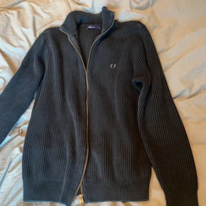 Stickad zipup - Mörkblå zip up tröja från Fred Perry. Strl. L men sitter overzised på mig som har XS/S så passar de flesta storlekar beroende på hur man vill att den ska sitta! Fint skick. 