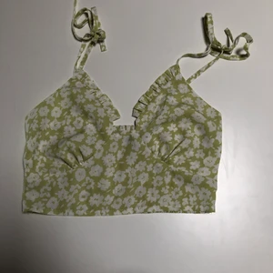Topp från SHEIN men sjusterbara band - Grön topp med blommor från SHEIN men smock i ryggen, sjusterbara band som man knyter aldrig använd så i bra skick!