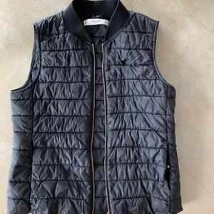 Dunväst - En marinblå/svart dunväst från Mango. Den är nästintill oanvänd med fickor på båda sidorna samt en guldig dragkedja. Perfekt till hösten! Jag har oftast st S eller M och den passar mig perfekt. 