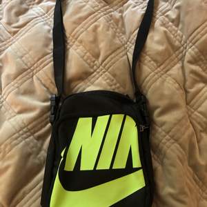 Axelväska från Nike med neongrönt tryck, en ficka på utsidan och avtagbart och justerbart band:)