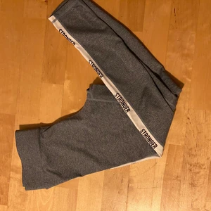 Stronges tränings tights - Här är ett par blå/gråa träningstights från stronger. Inga synliga fel men det tryckta storleks och tvättrådet håller på att slitas av.